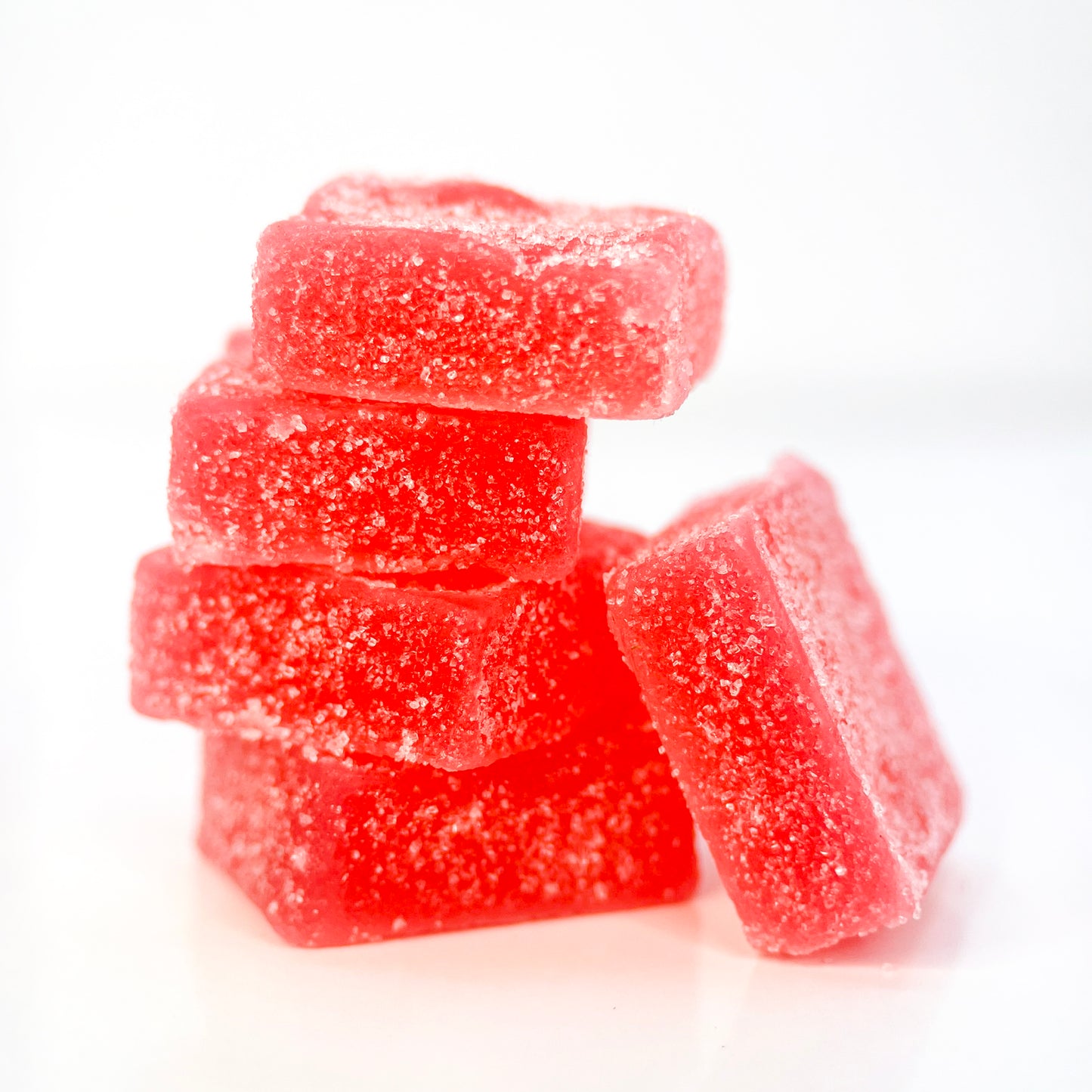 A small pile of SasquaTHCa Strawberry Gummies, featuring their bright red color, chewy texture, and the sweet, juicy flavor of ripe strawberries infused with THCa.